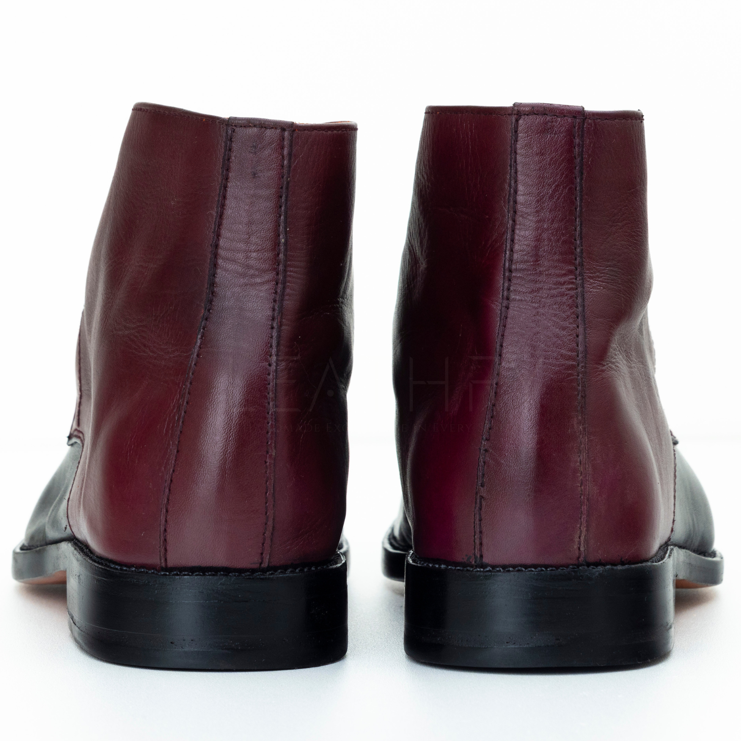 Pair of maroon leather boots on a white background