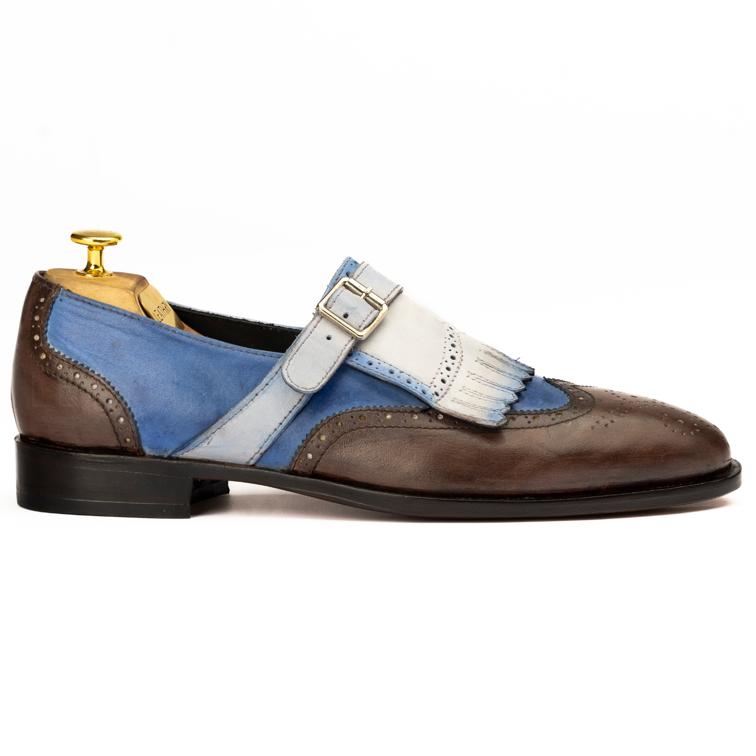 Brown and blue shoe with a white strap and gold buckle on a white background