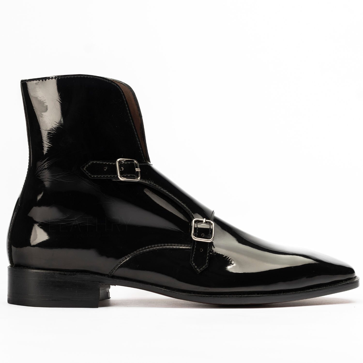 Black patent leather boot with buckle on a white background