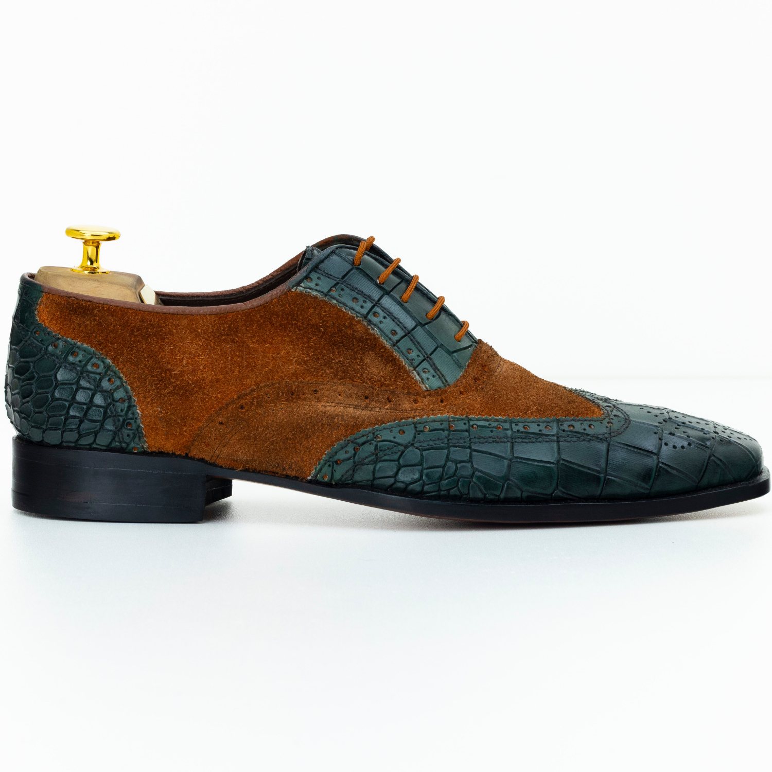 Brown and green leather shoe with crocodile pattern on a white background