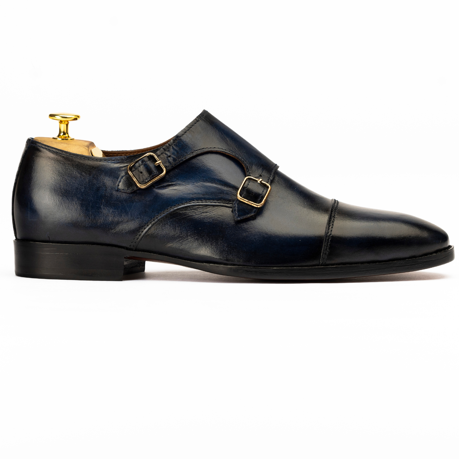 Black leather dress shoe with gold buckles on a white background