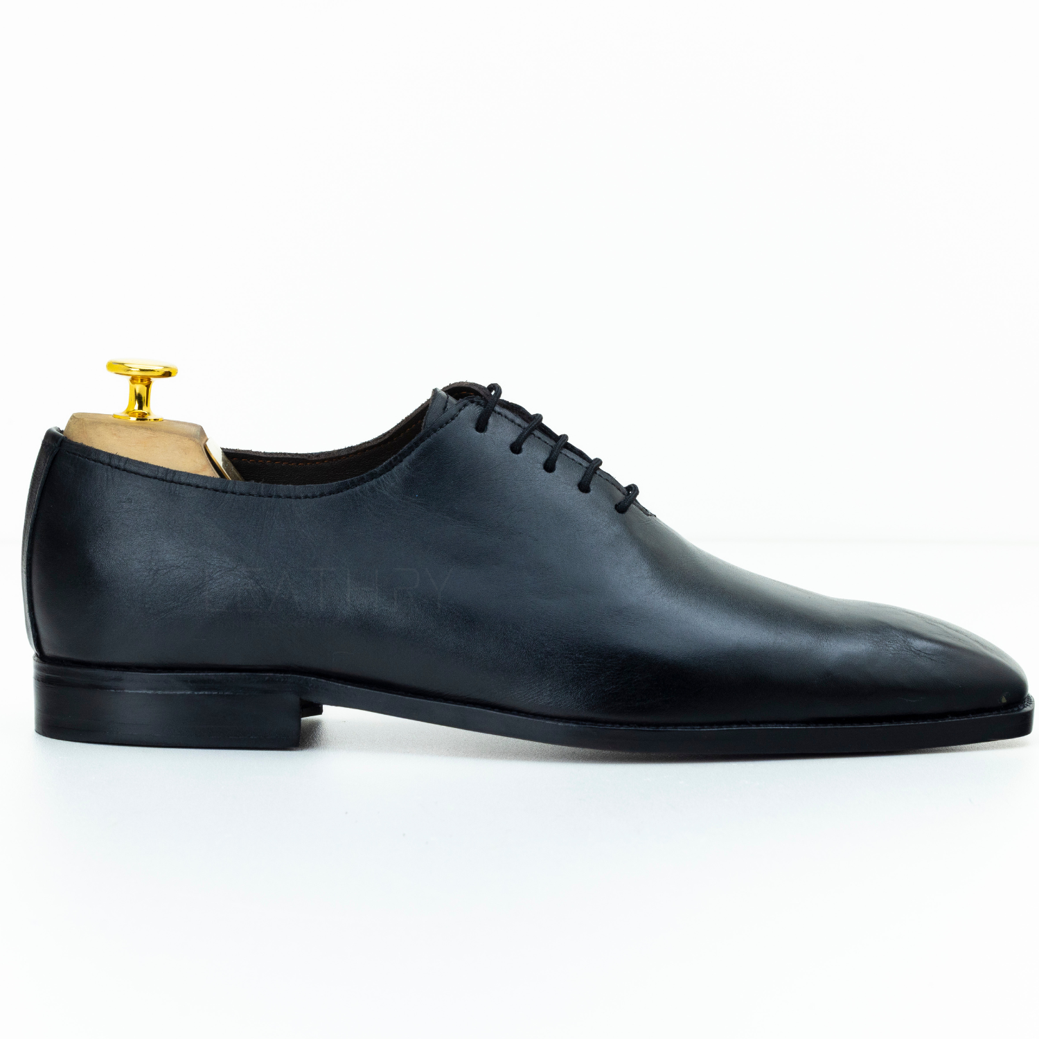 Black leather dress shoe on a white background