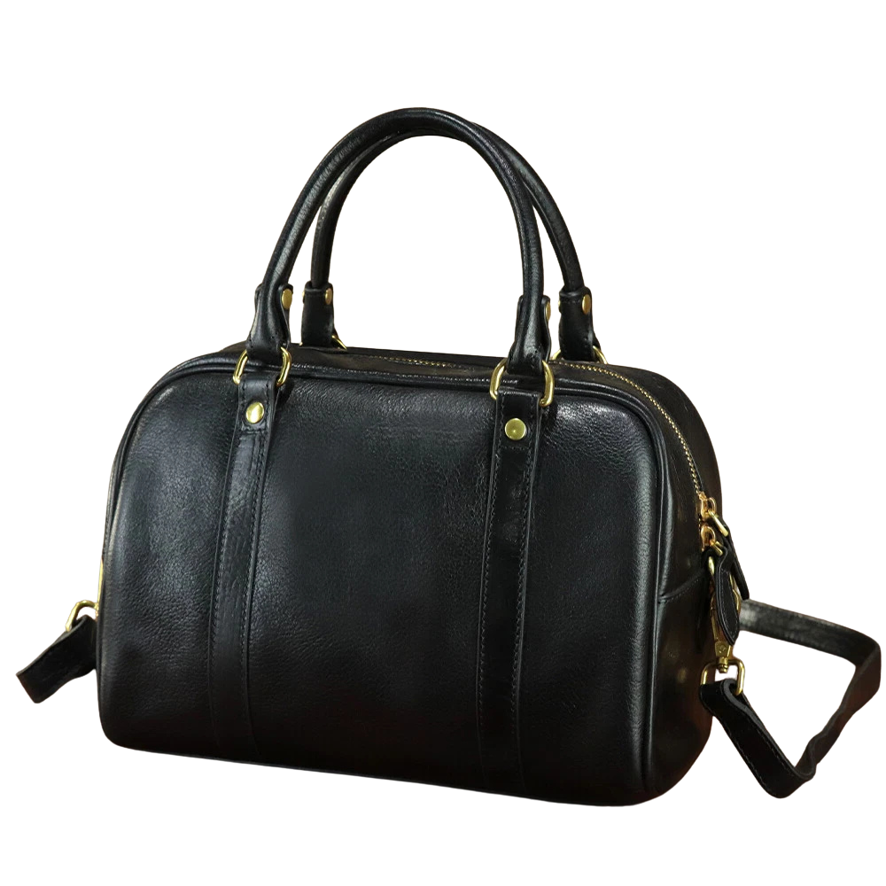Black leather handbag with gold accents on a white background