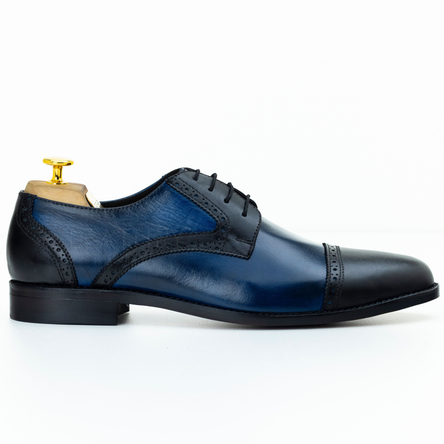 Blue and black leather dress shoe on a white background