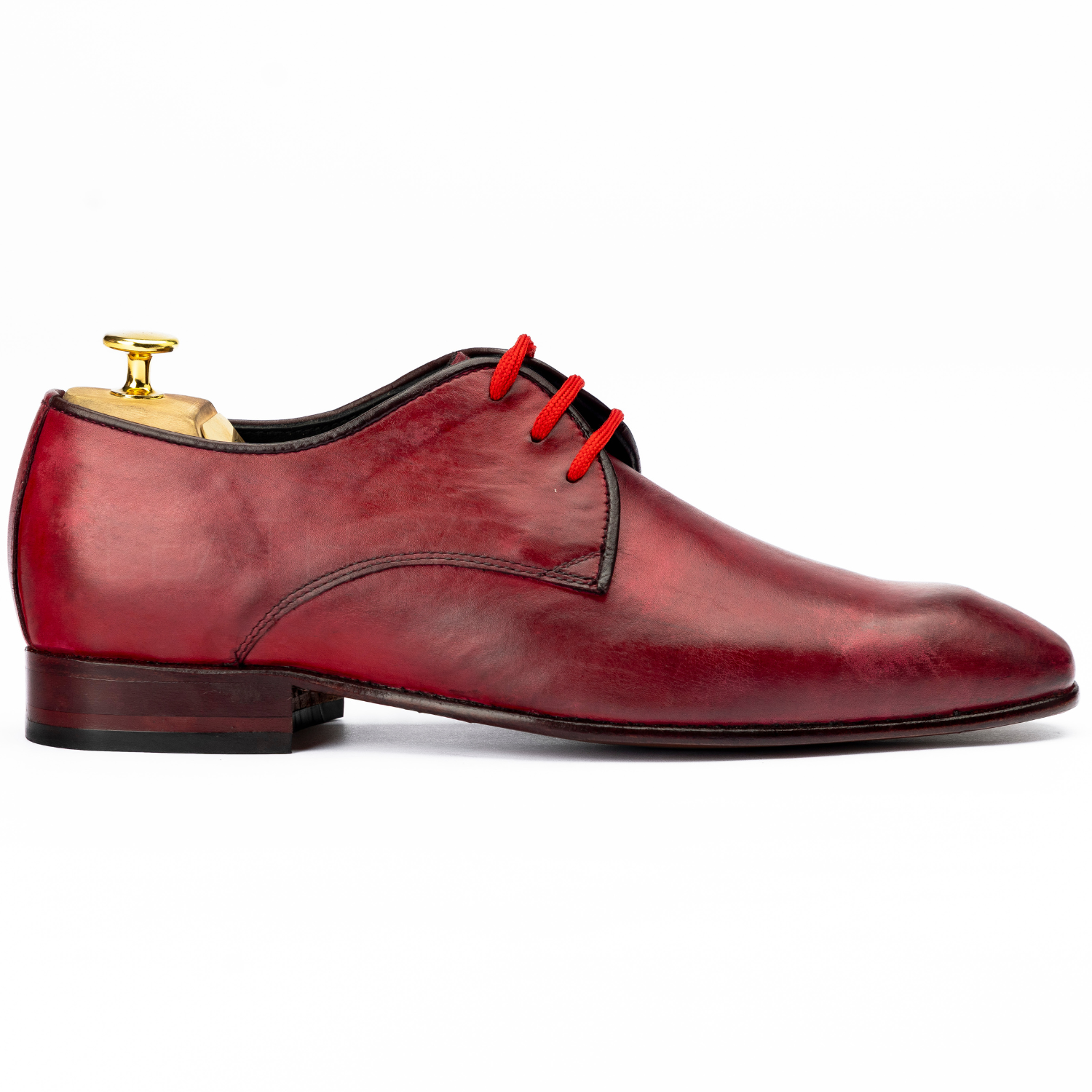 Red leather dress shoe with red laces on a white background