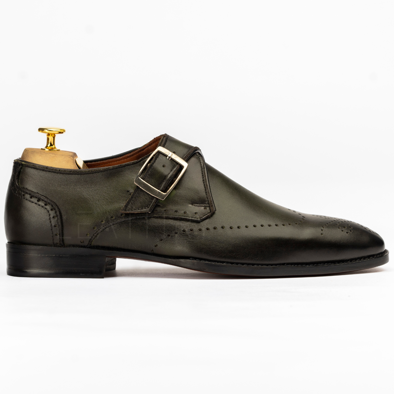 Green leather dress shoe with a gold buckle on a white background