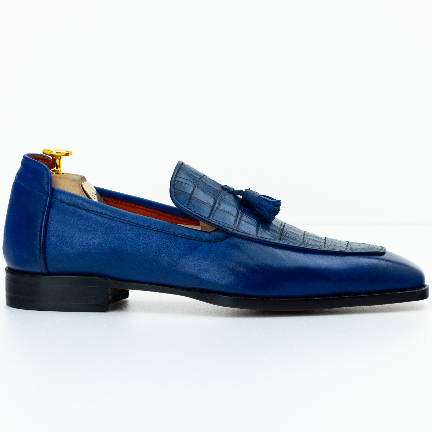 Blue leather loafer with a tassel on a white background