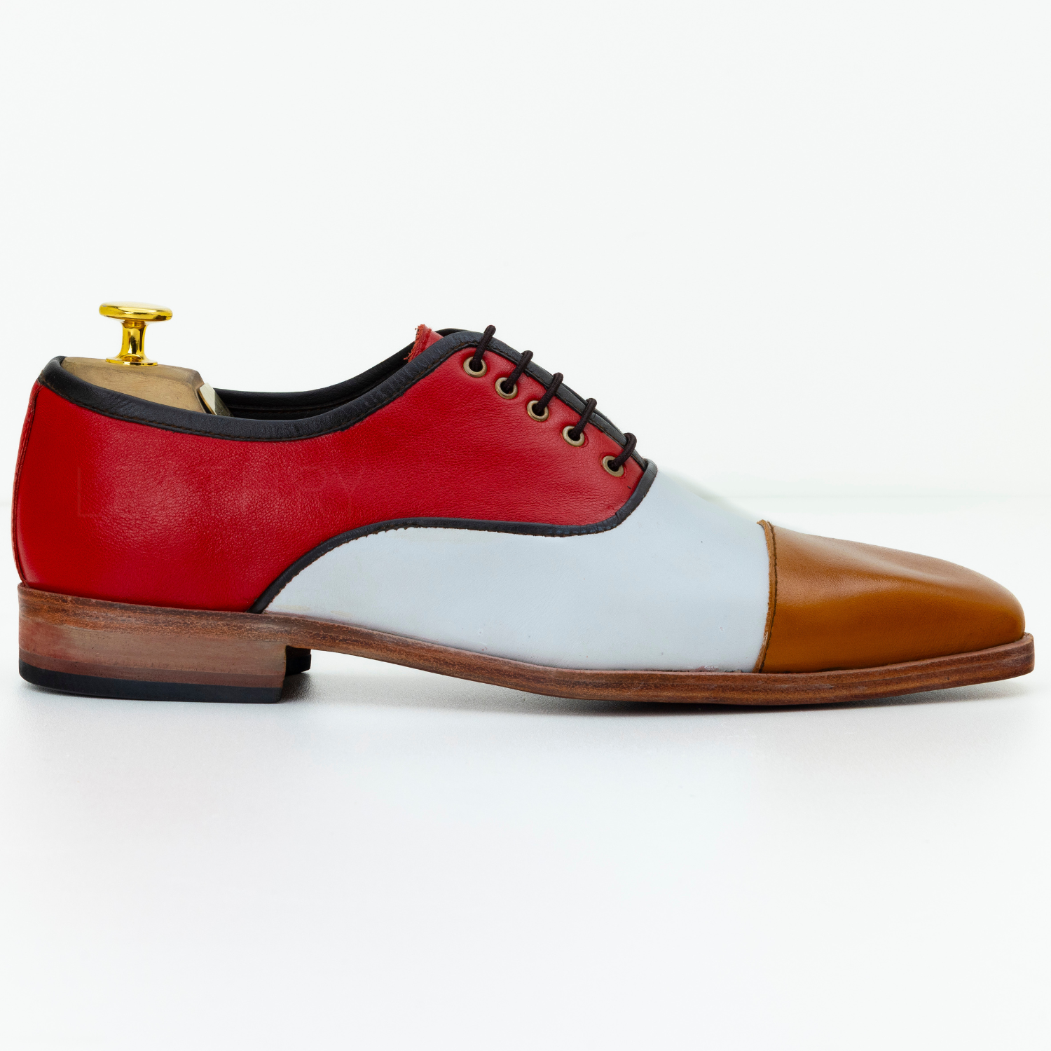 Multicolored shoe with red, white, and brown sections on a white background
