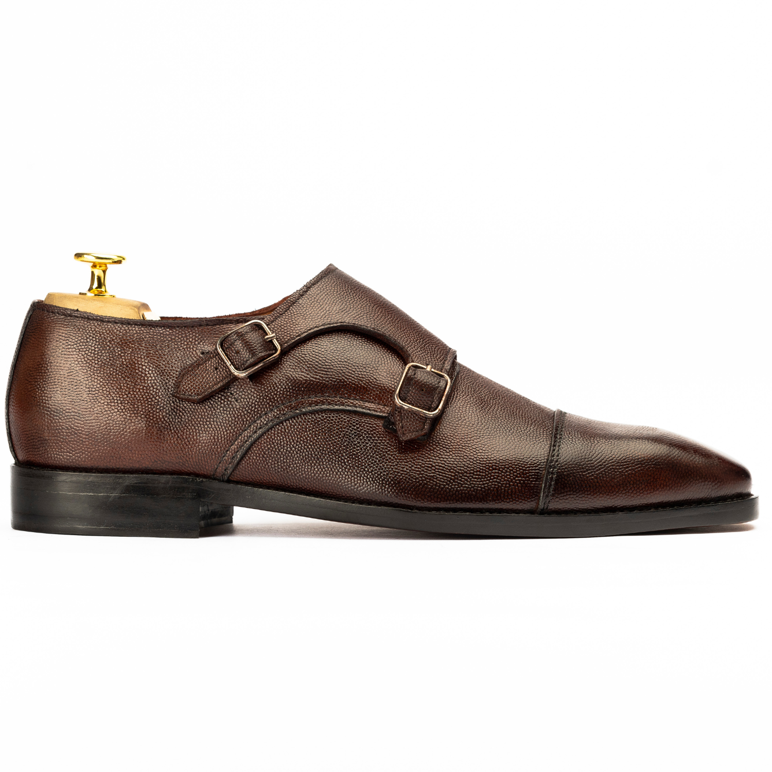 Brown leather dress shoe with gold buckle on a white background