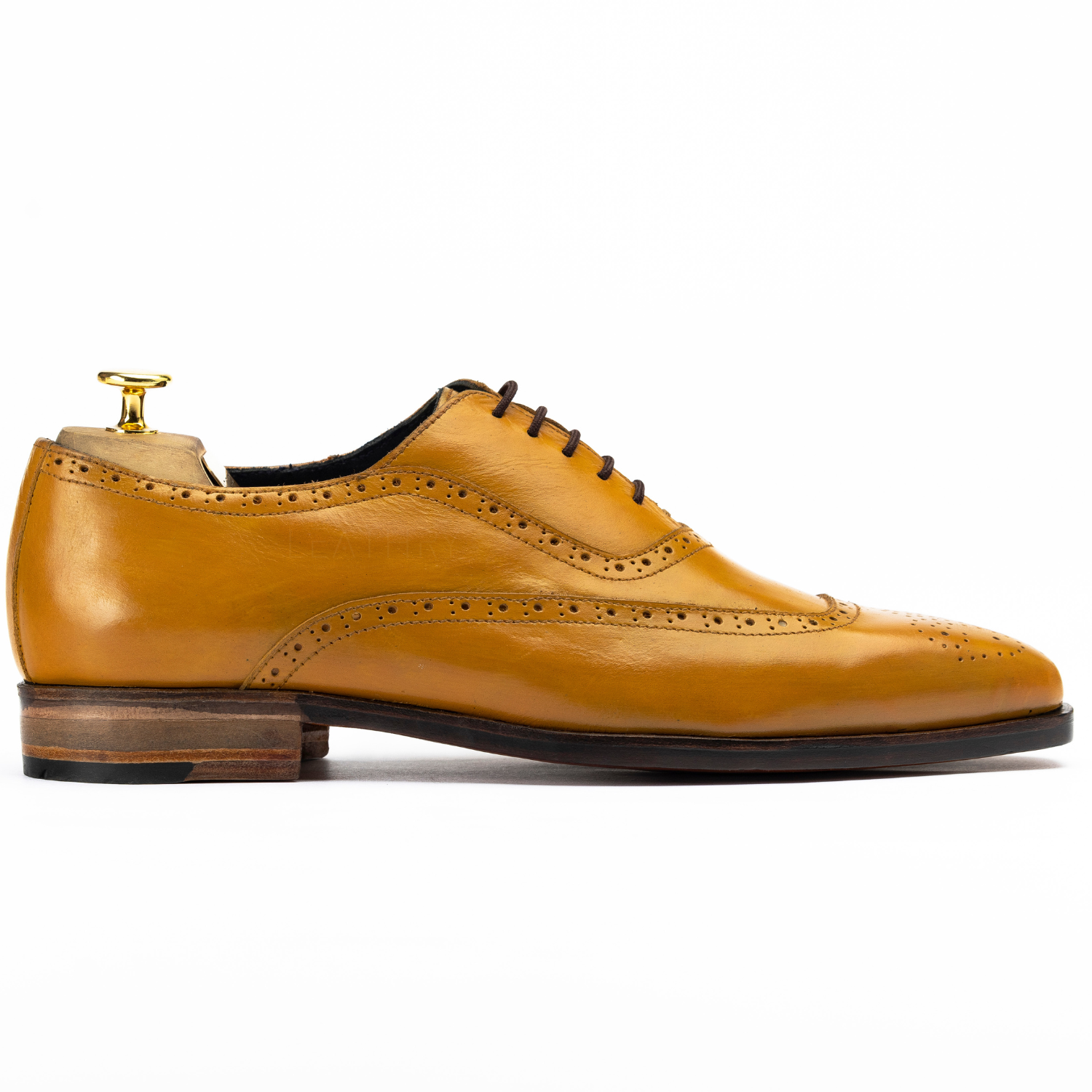 Yellow leather dress shoe with a white background