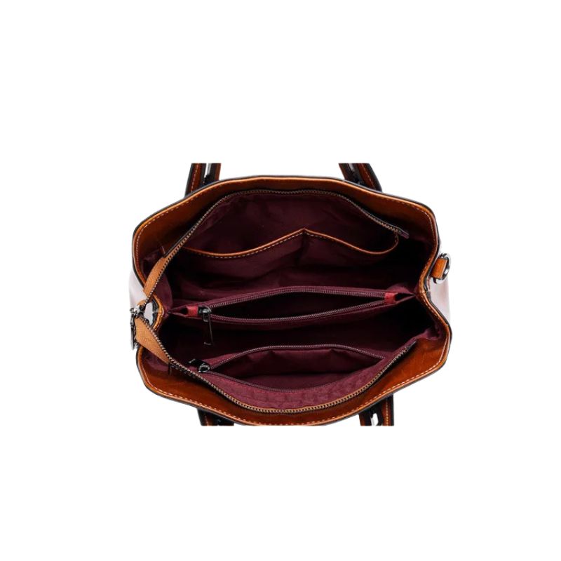 Brown leather handbag with open interior on a white background