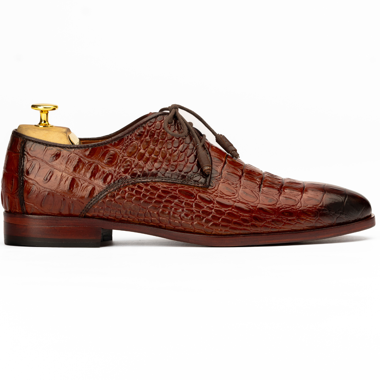 Brown crocodile-patterned shoe on a white background