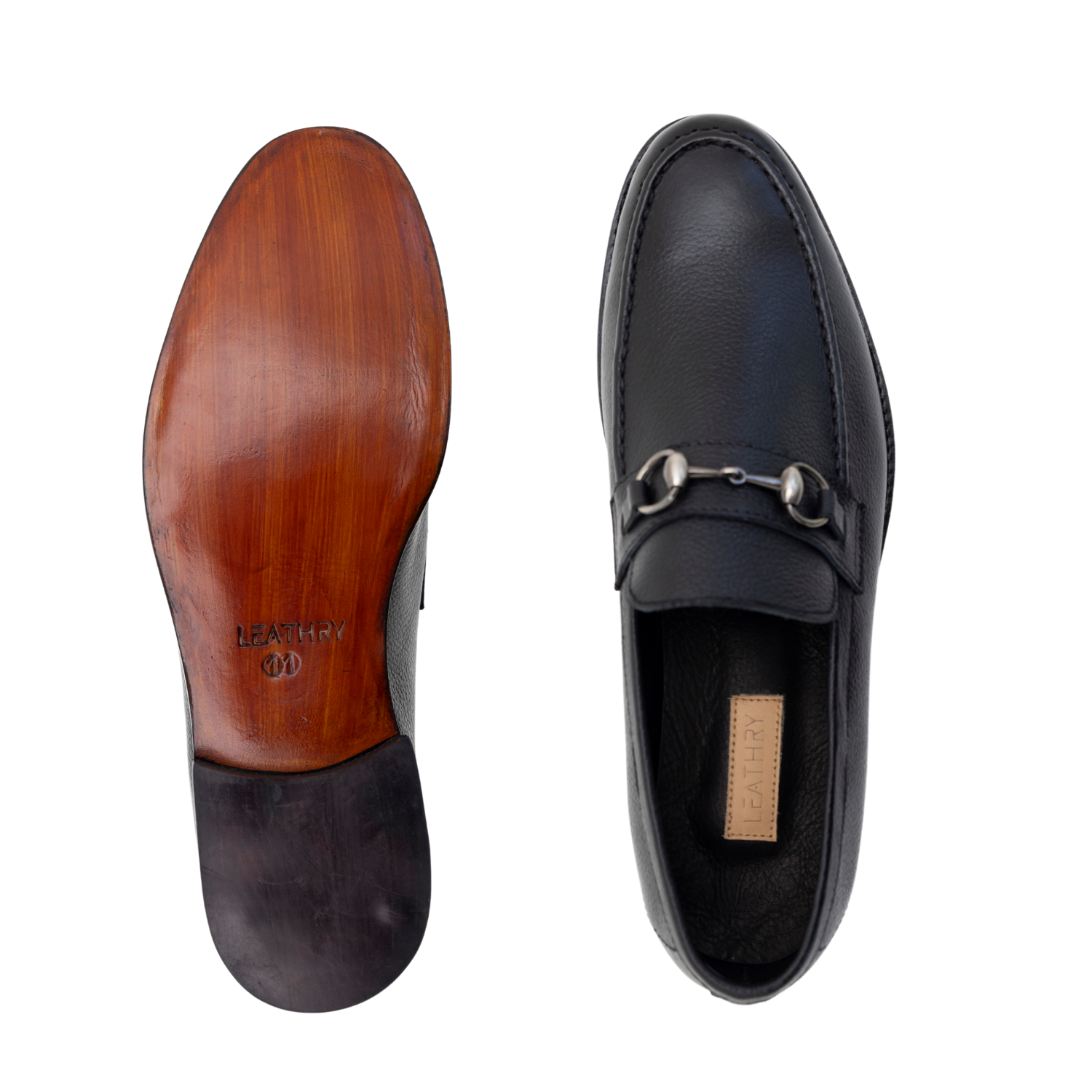 Black loafer shoe with wooden sole on a white background