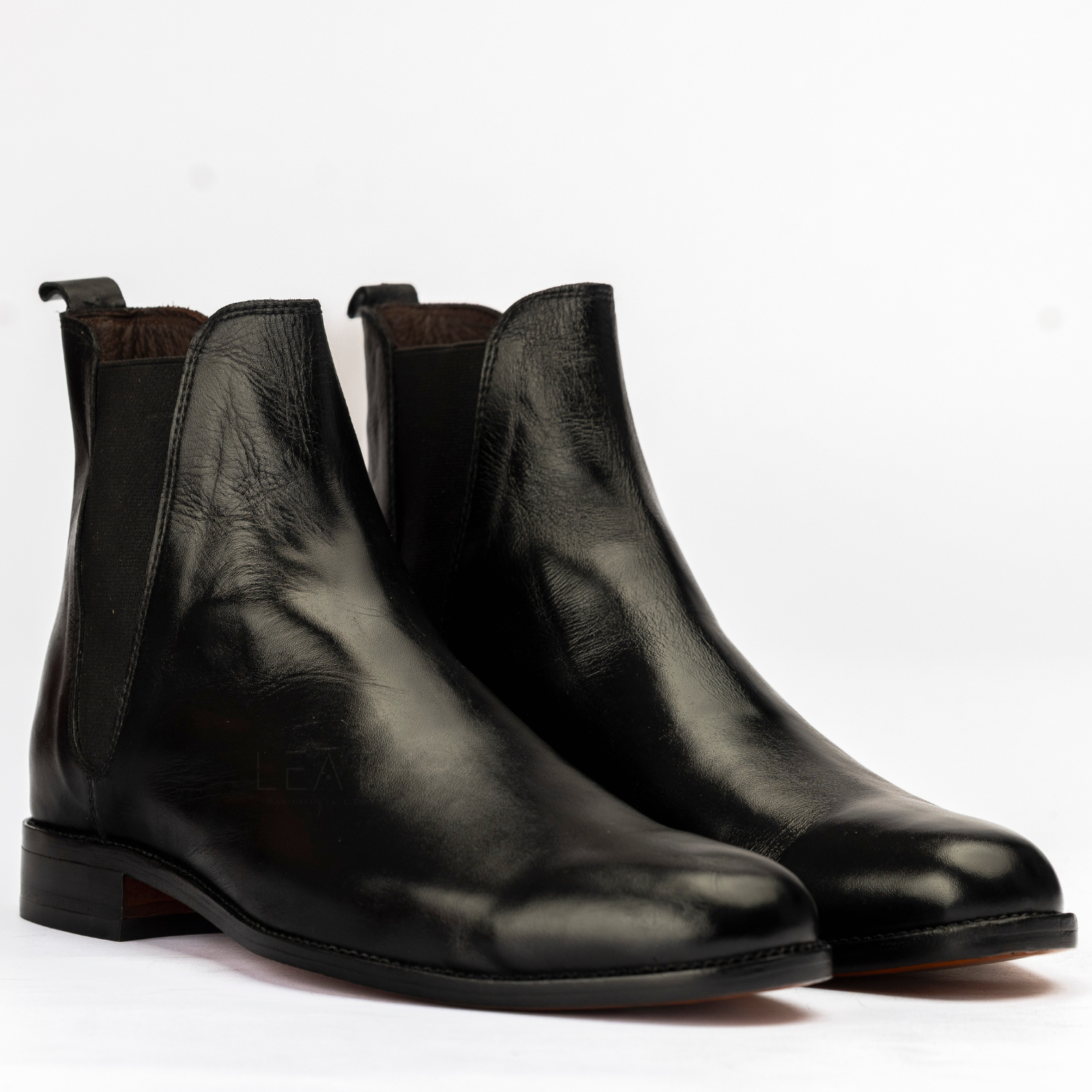 Pair of black leather Chelsea boots on a white background