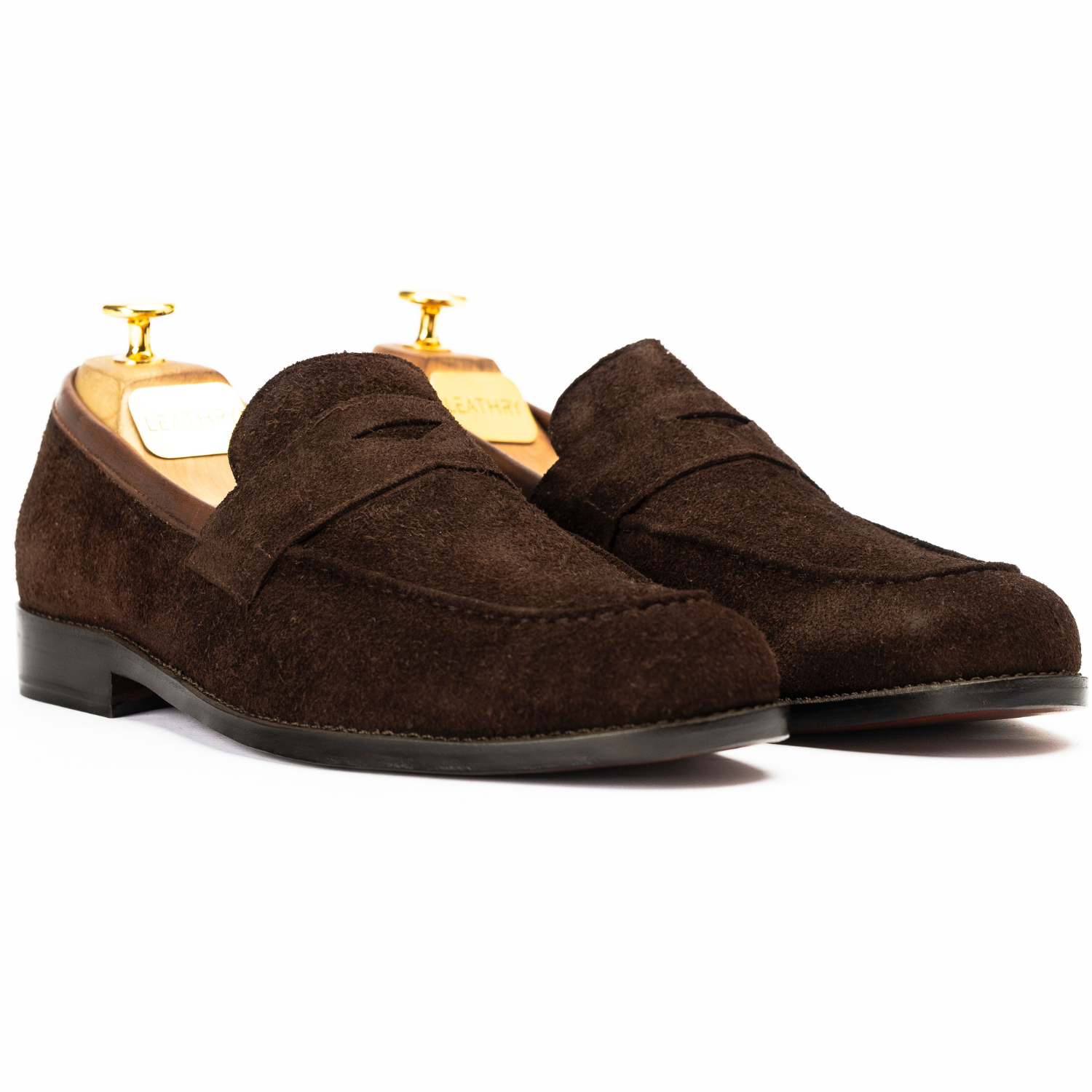 Pair of brown suede loafers on a white background