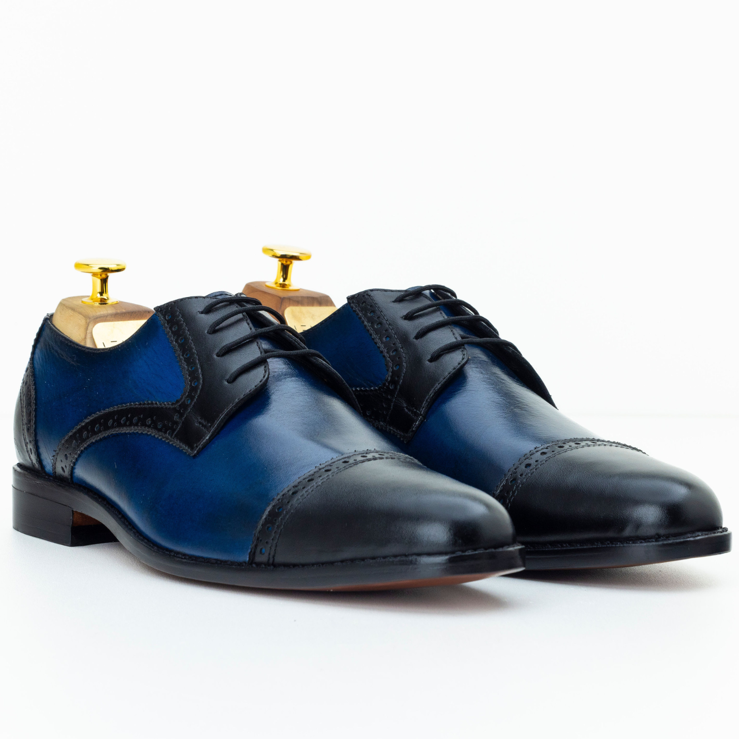 Pair of blue and black dress shoes on a white background