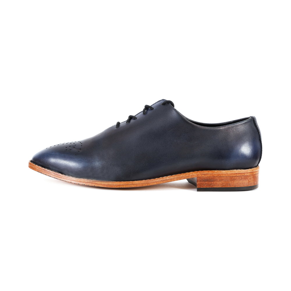 Black sneaker with a distinctive sole pattern on a white background