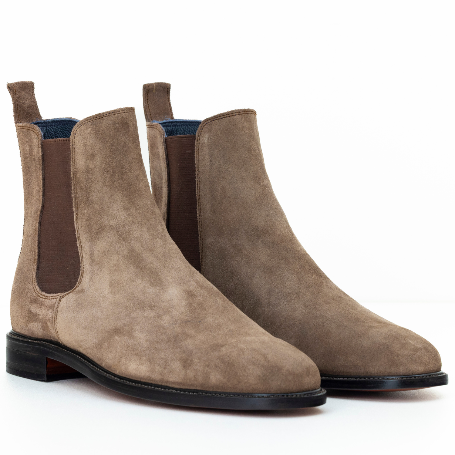 Pair of brown suede Chelsea boots on a white background