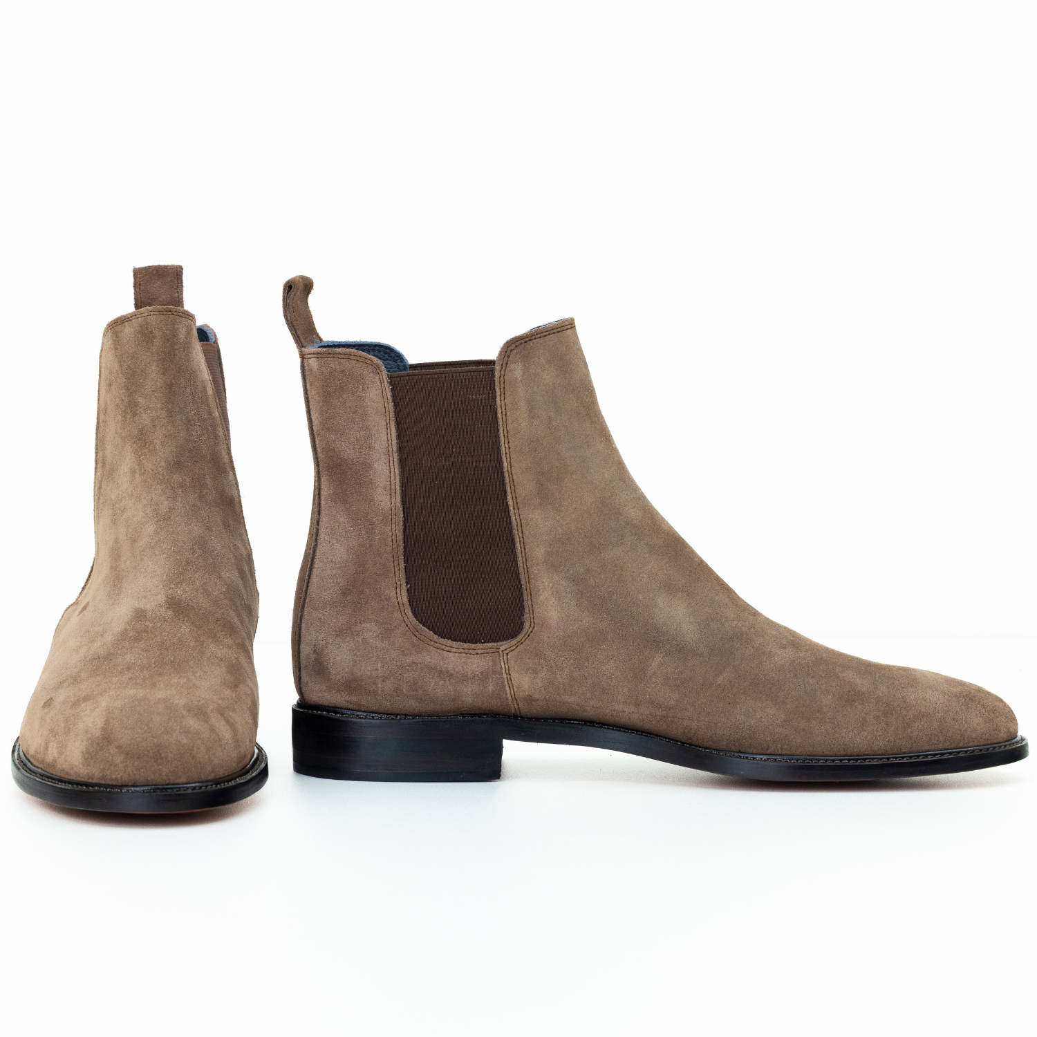 Pair of brown suede Chelsea boots on a white background