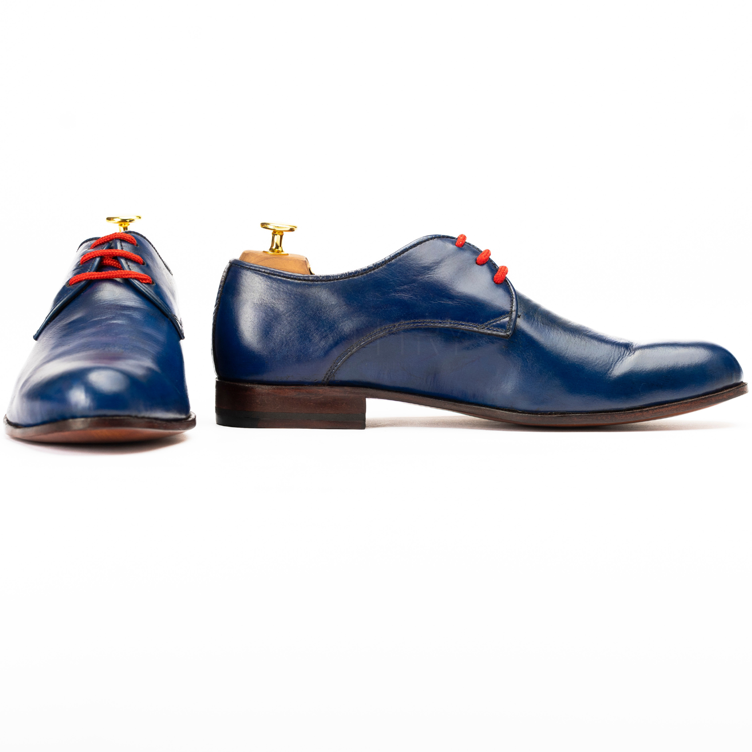 Pair of blue dress shoes with red laces on a white background
