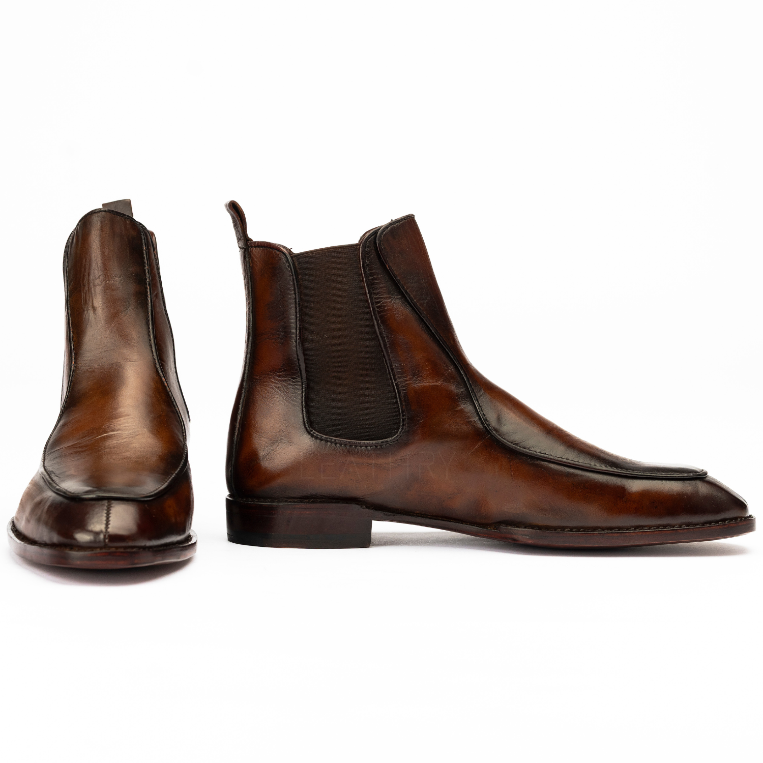 Pair of brown leather Chelsea boots on a white background