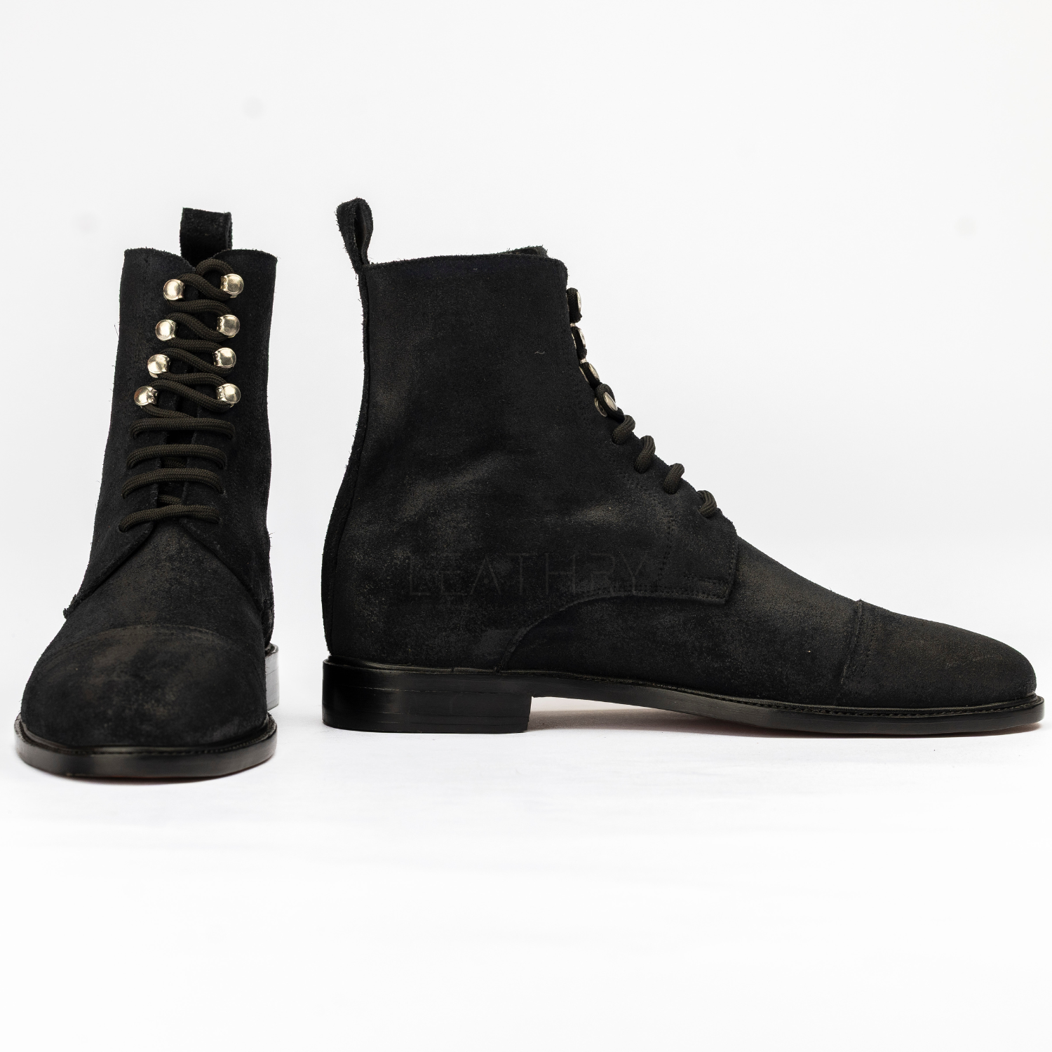 Pair of black suede boots on a white background