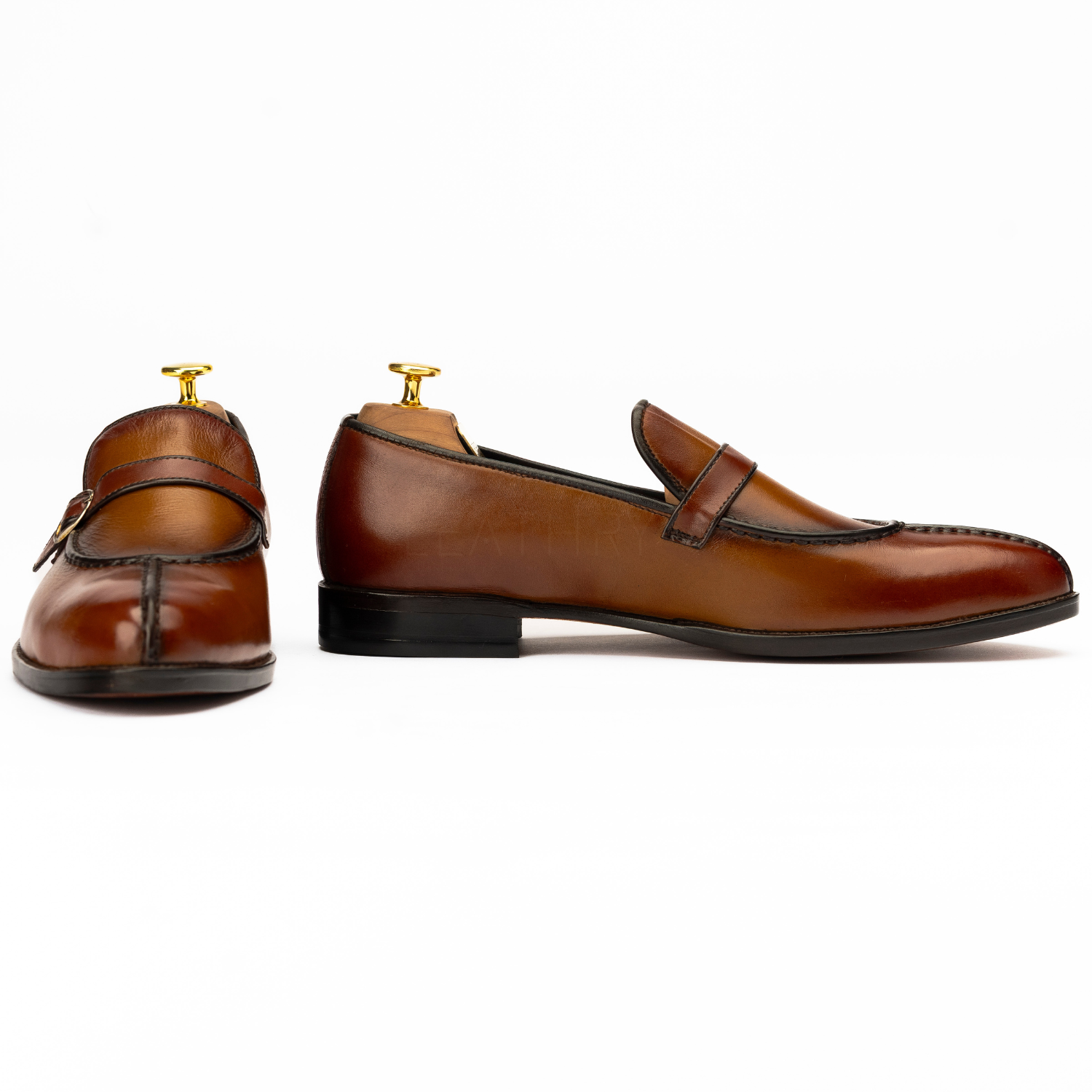 Pair of brown leather loafers on a white background