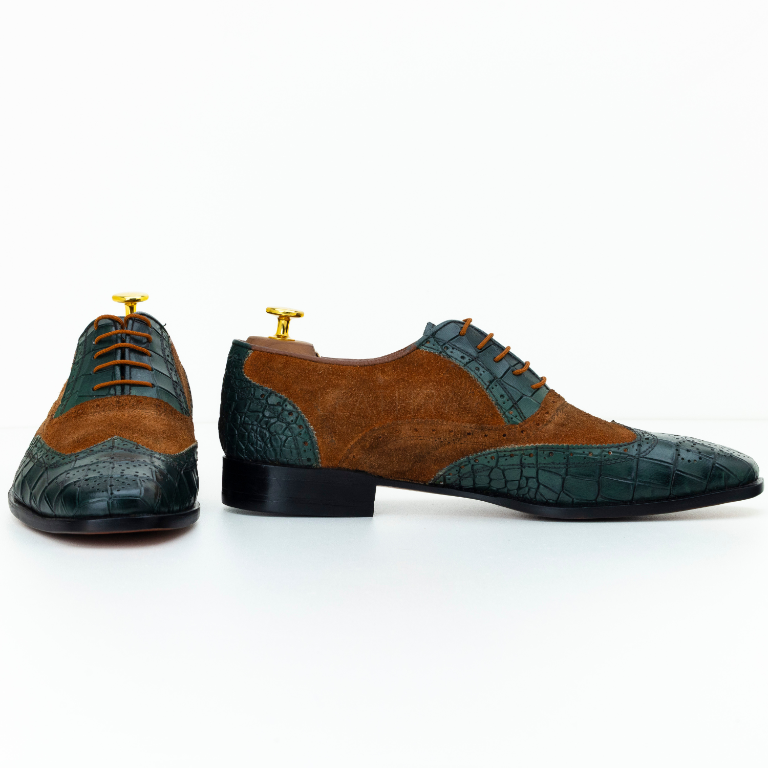 Brown and green dress shoes with crocodile pattern on a white background