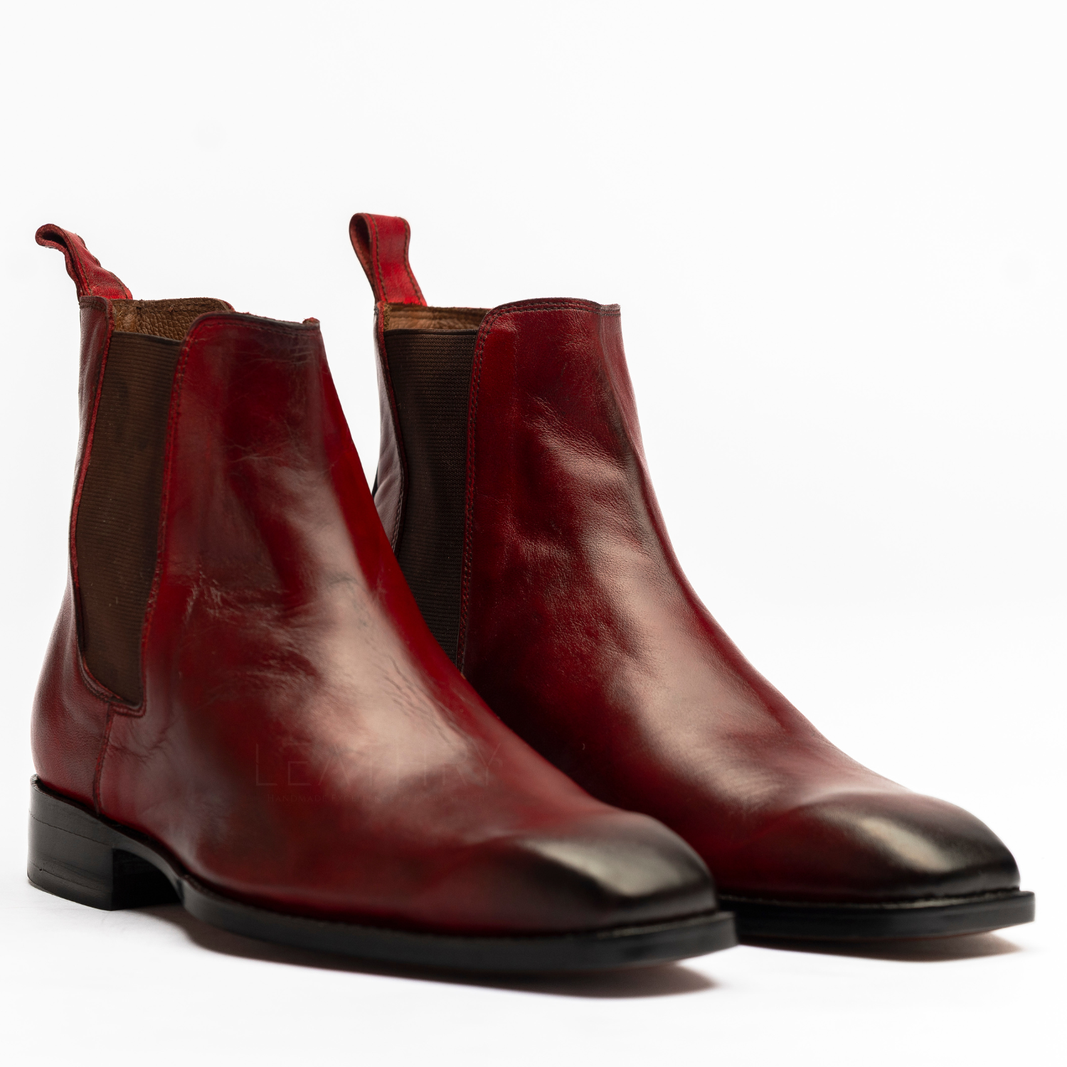 Pair of red leather boots on a white background