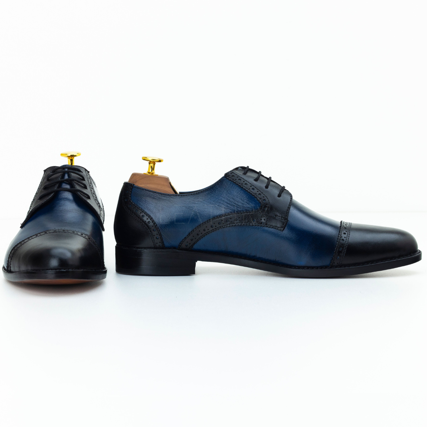 Pair of blue and black dress shoes on a white background