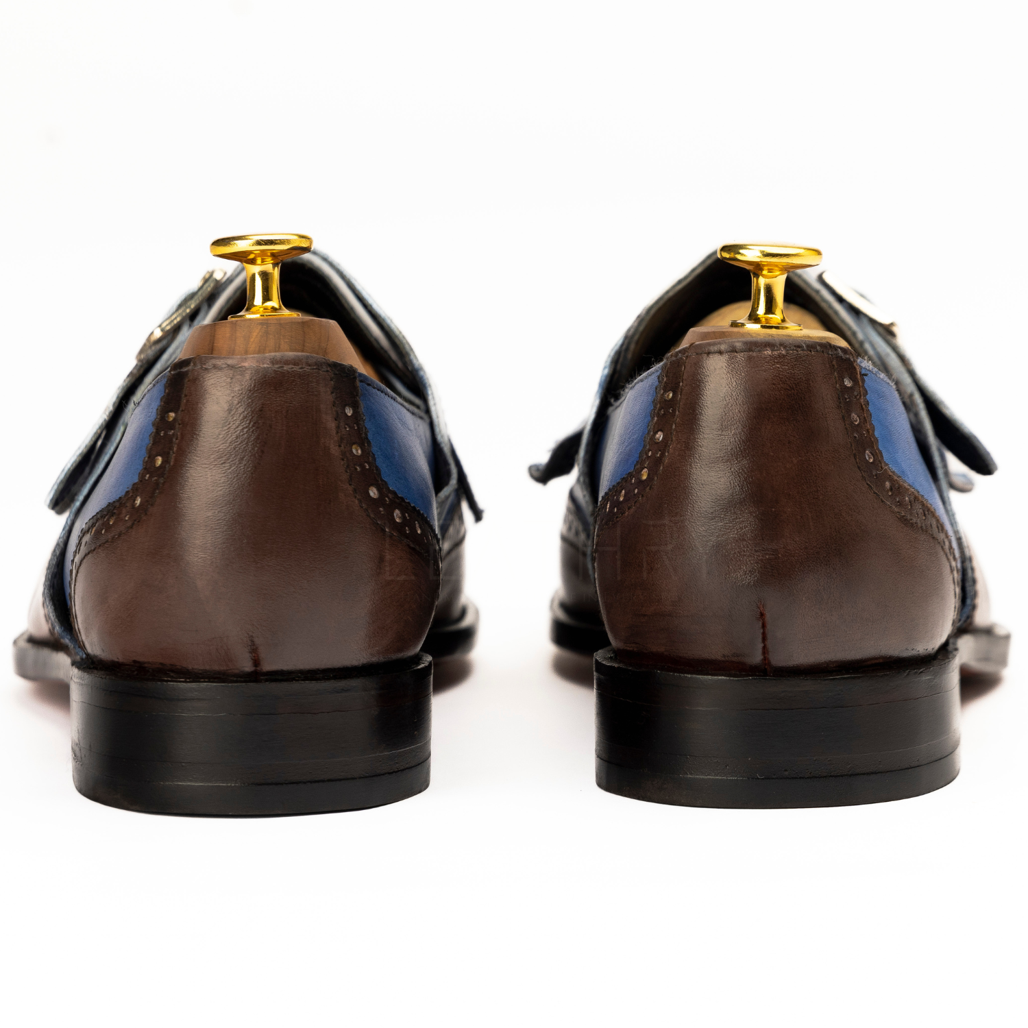 Brown dress shoes with gold tips on a white background