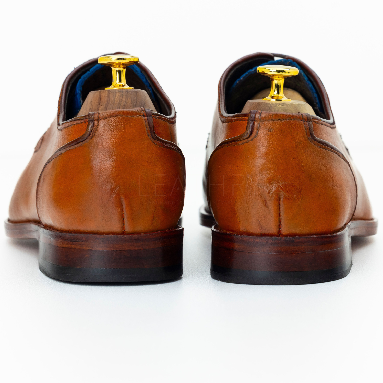 Pair of brown leather dress shoes on a white background