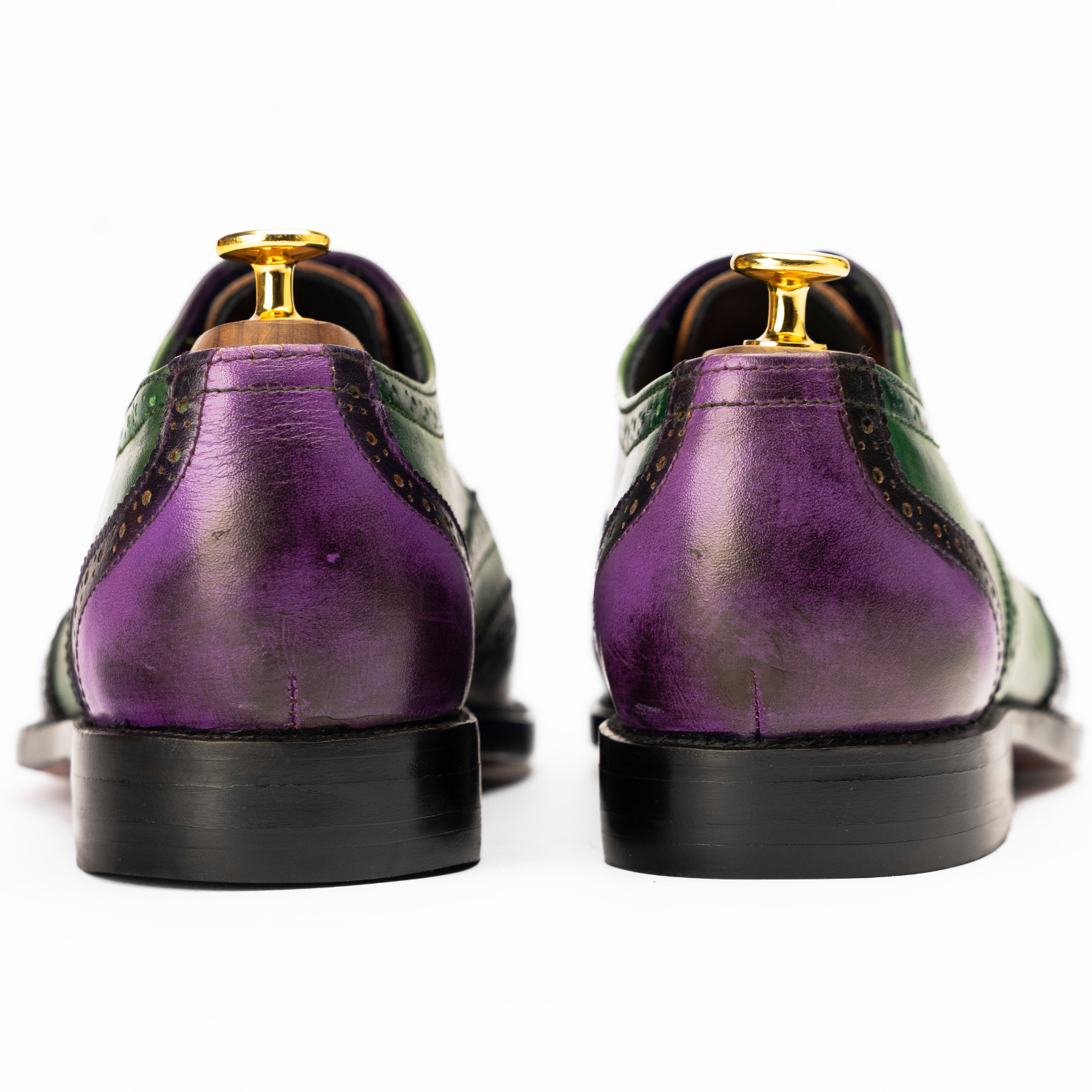 Purple and green shoes with gold accents on a white background