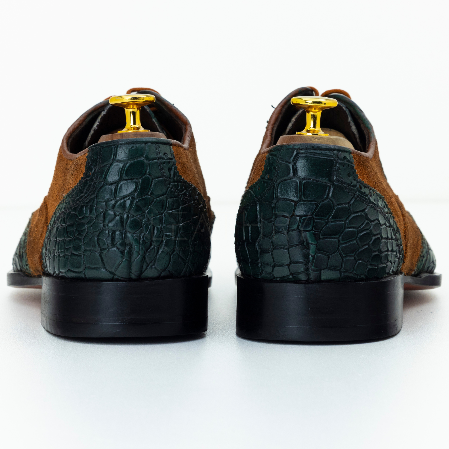 Pair of brown and green patterned shoes on a white background