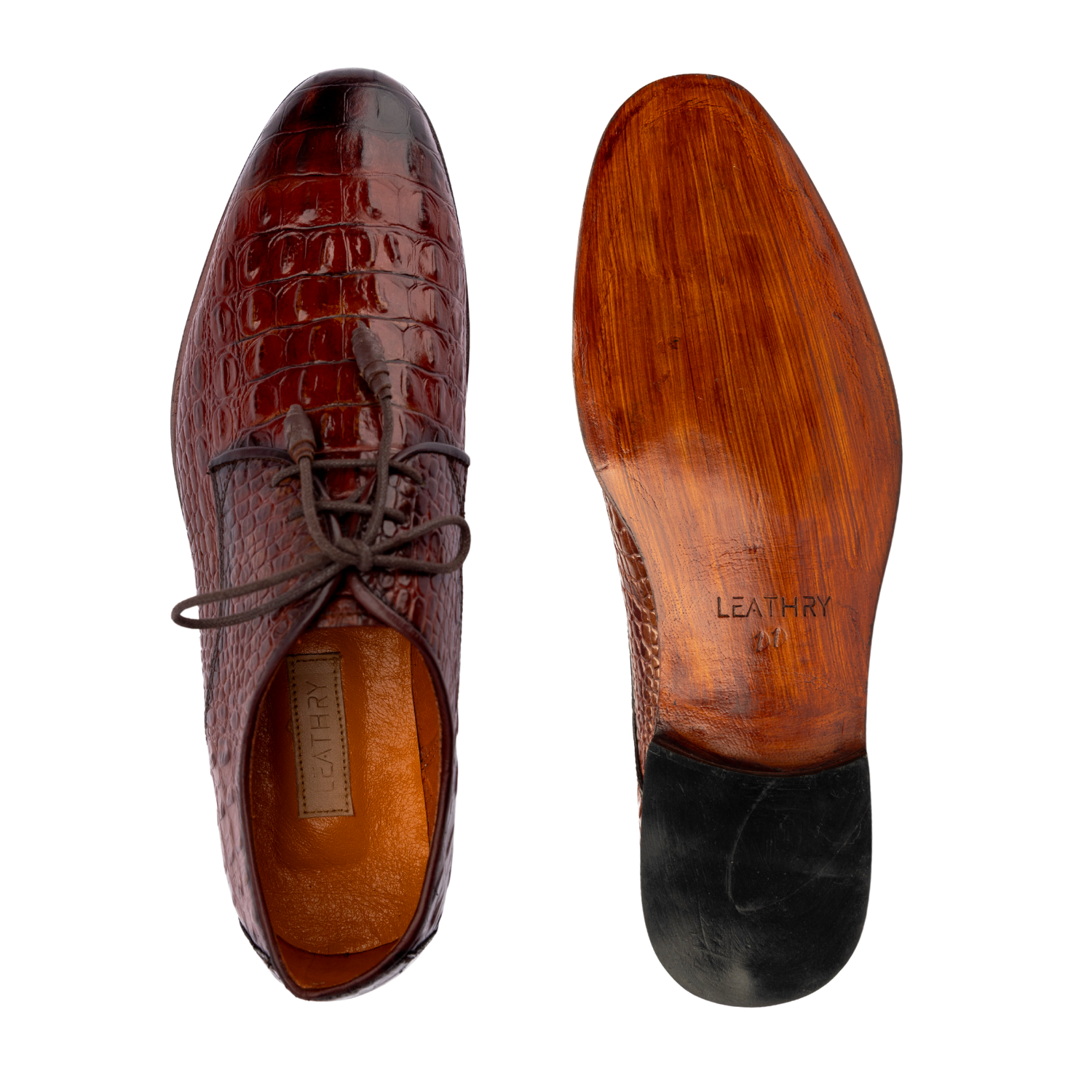 Brown leather shoe with crocodile texture and wooden sole on a white background