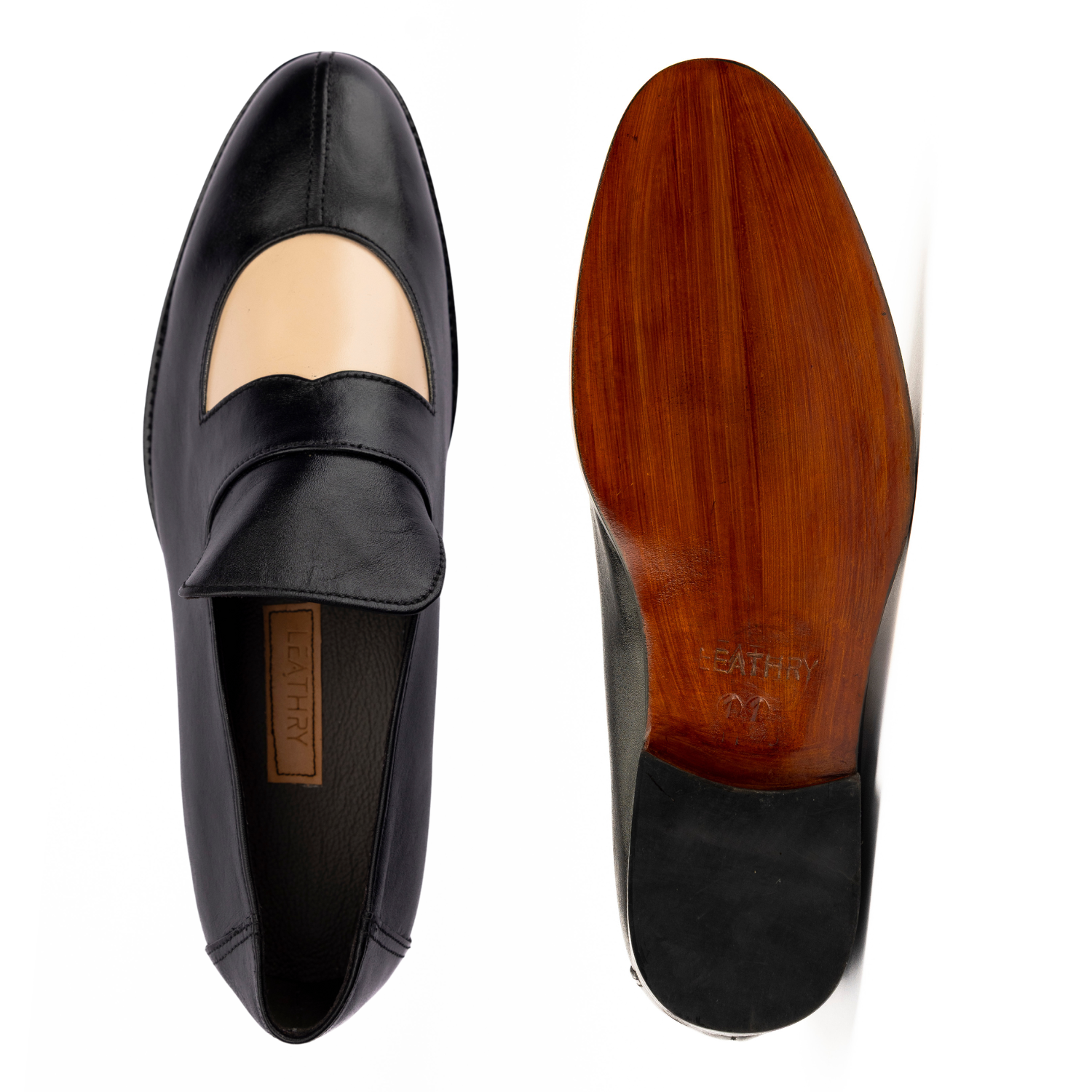 Black loafer shoe with wooden sole on a white background