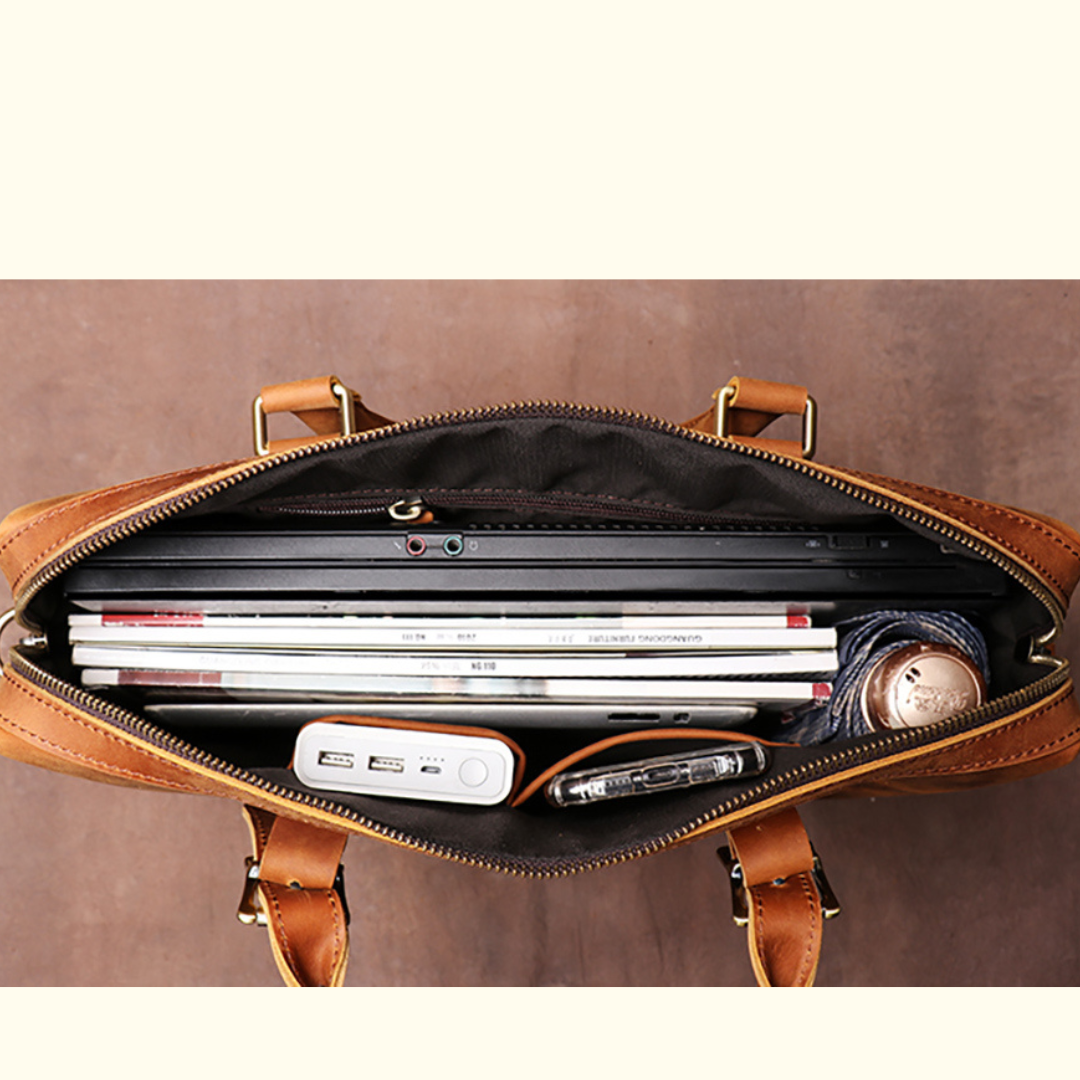 Brown leather briefcase with laptop and documents on a brown background