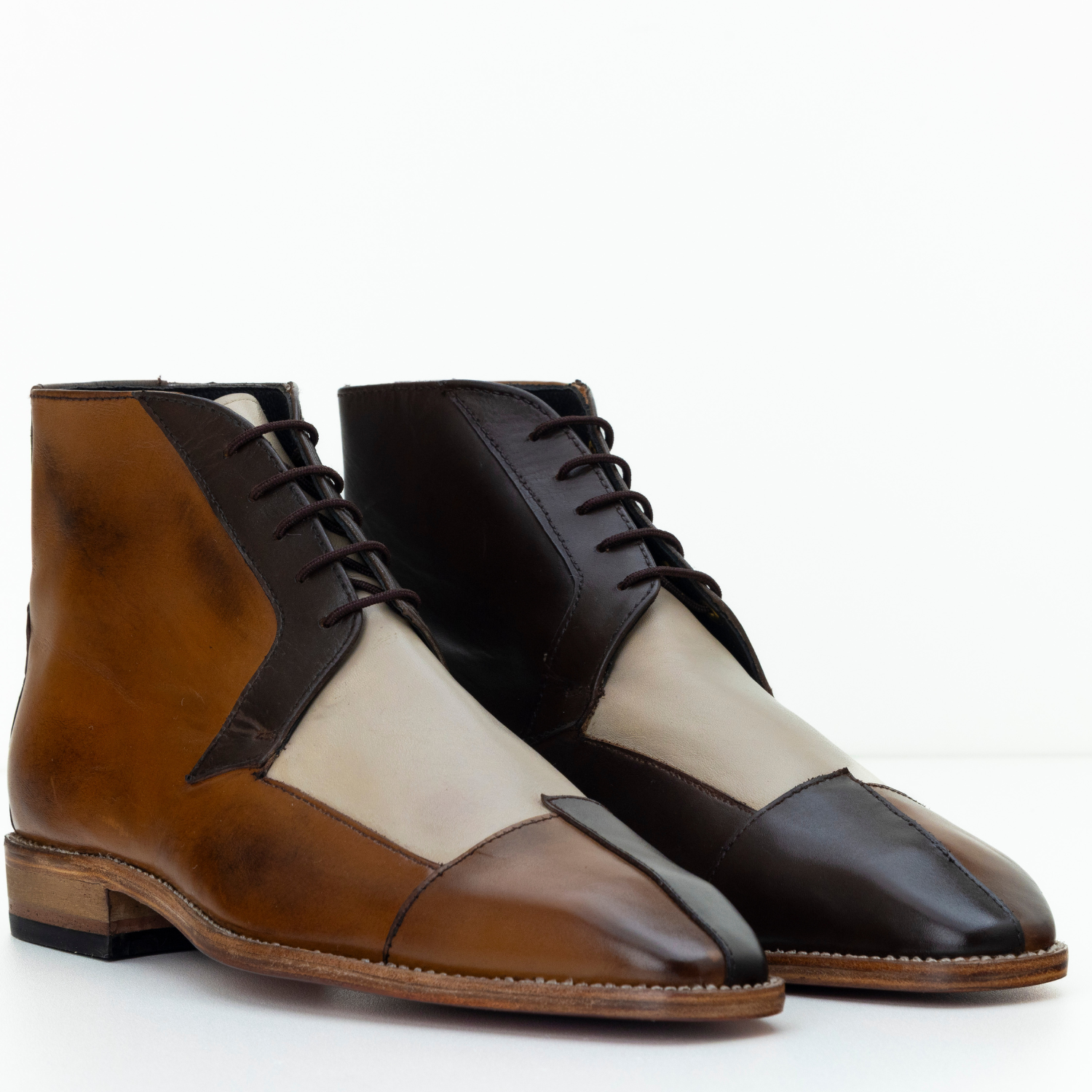 Pair of brown, black, and beige leather shoes on a white background