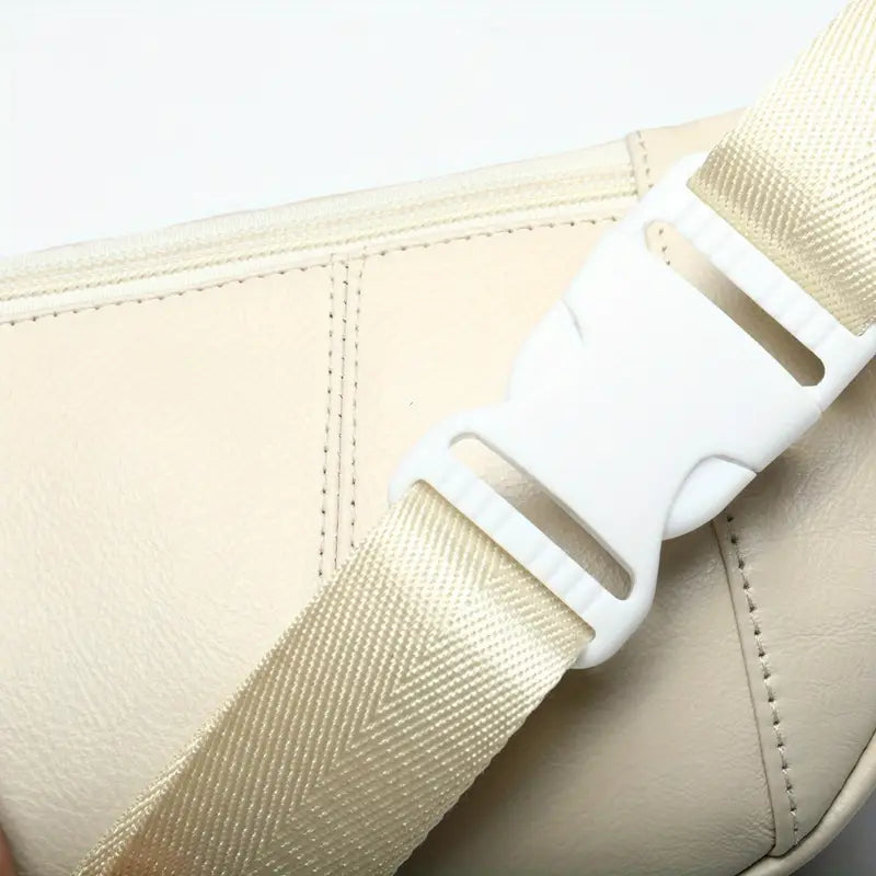 Close-up of a beige seat belt with a white buckle on a car interior.