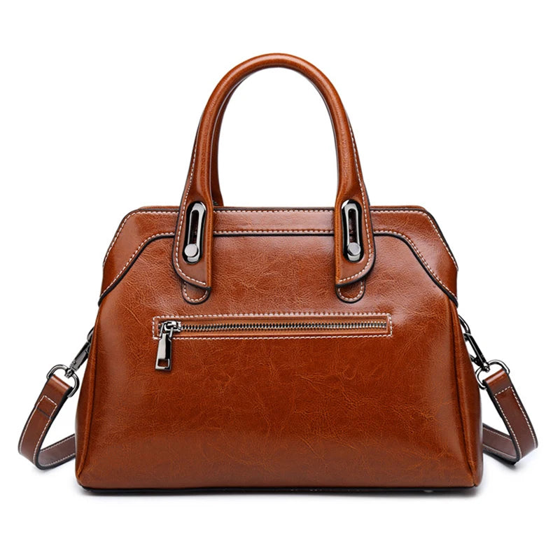 Brown leather handbag with a shoulder strap on a white background
