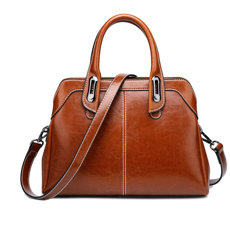 Brown leather handbag with a shoulder strap on a white background