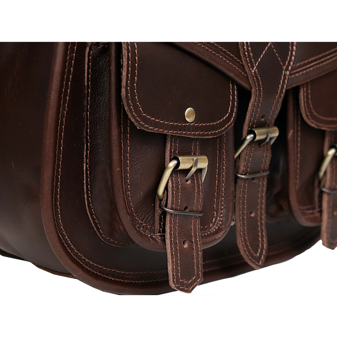 Close-up of a brown leather bag with gold buckles on a white background