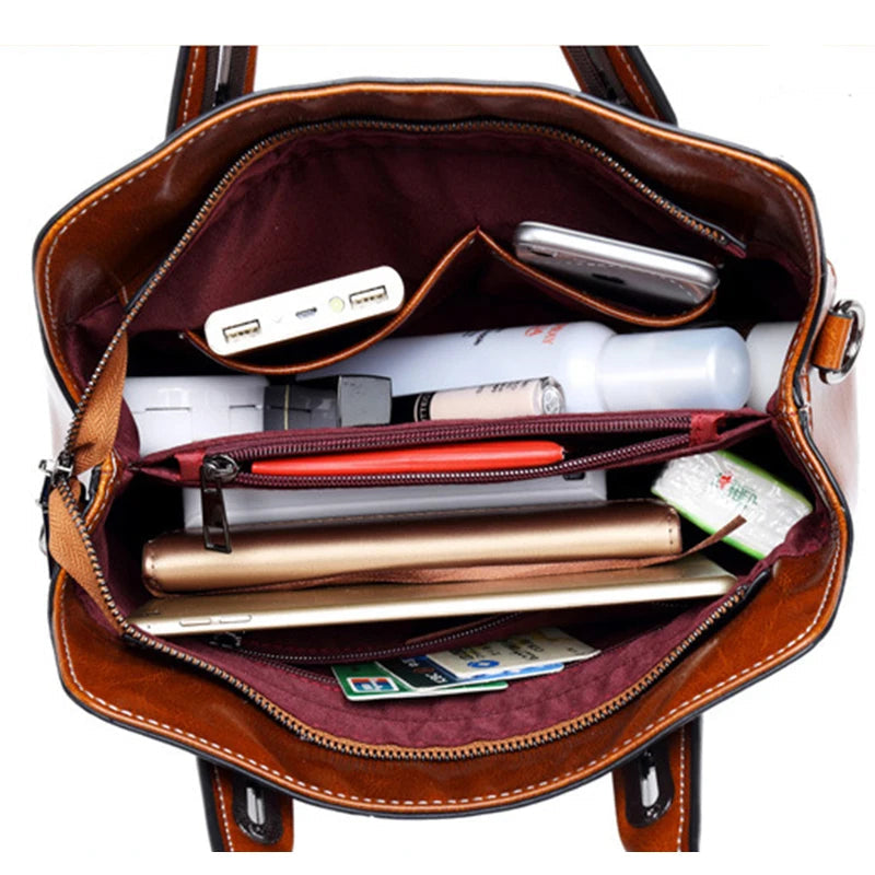 Open brown leather handbag with various items including a phone, pen, and money.