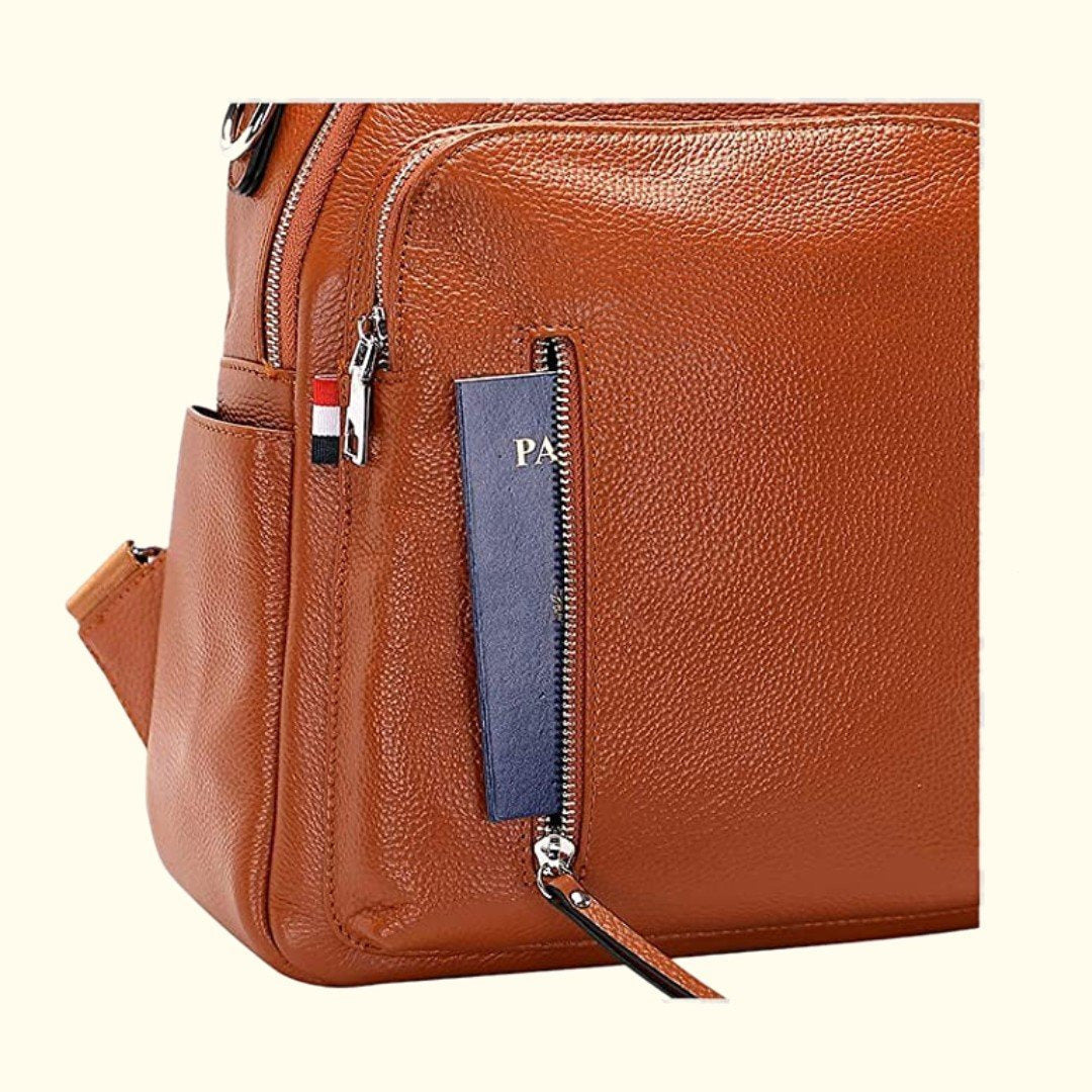 Brown leather bag with zippers and a visible brand logo on a white background