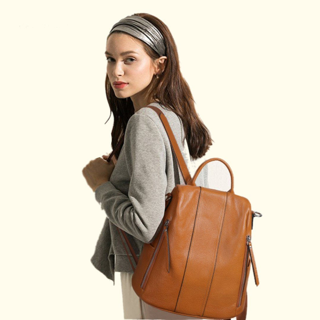 Woman carrying a brown leather backpack on a white background