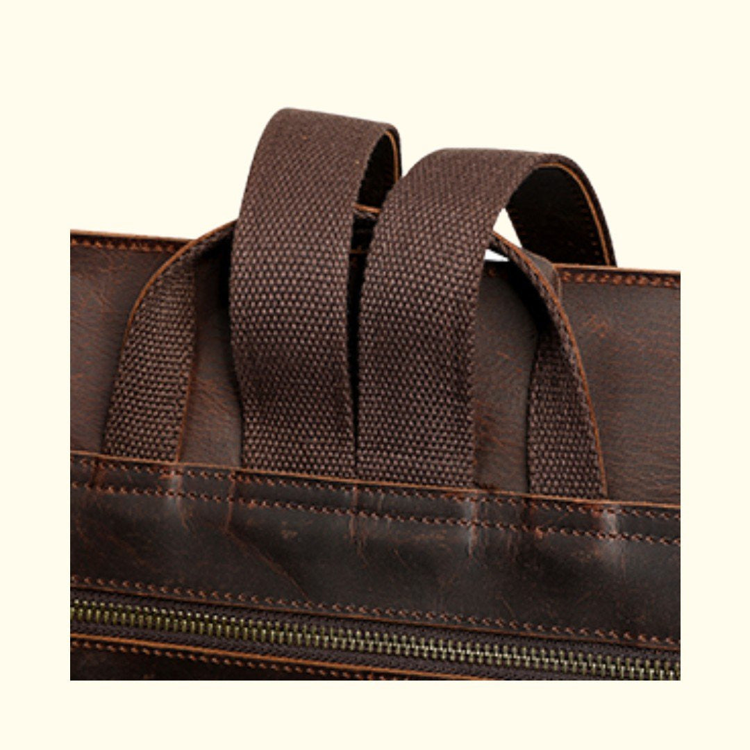 Close-up of a brown leather bag with handles and zipper