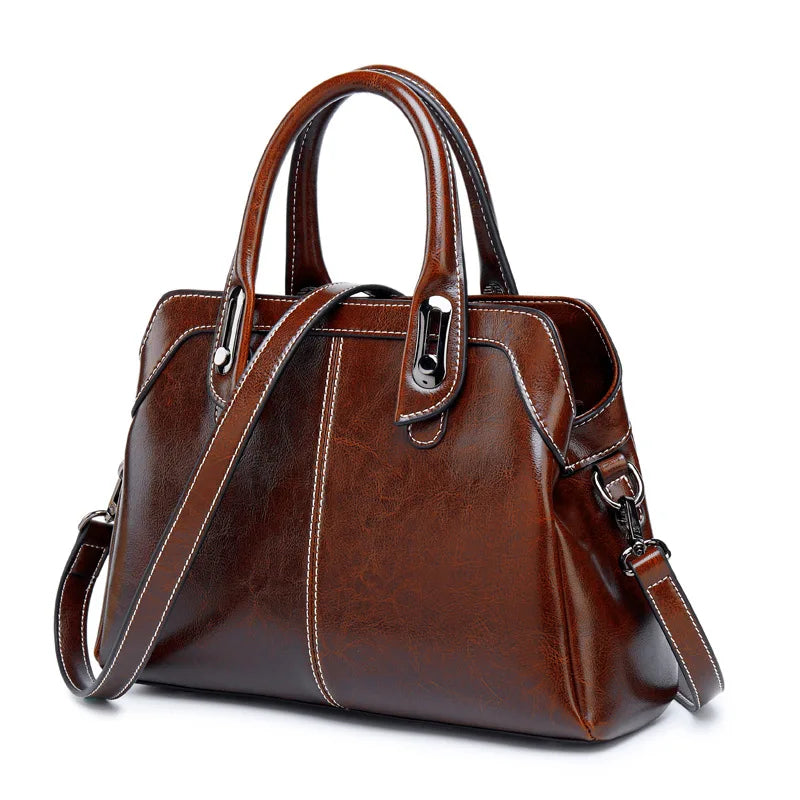Brown leather handbag with a shoulder strap on a white background
