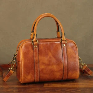 Brown leather handbag on a wooden surface with a brown background