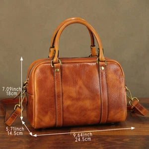 Brown leather handbag with measurements on a wooden surface and brown background