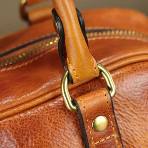 Close-up of a brown leather bag with gold hardware